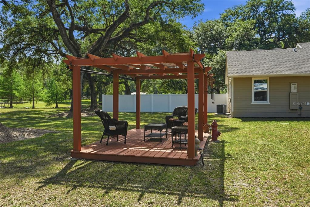 7037 County Road 625 Bushnell, FL 33513 - Photo 60 of 99 a view of a patio with table and chairs potted plants and a large tree