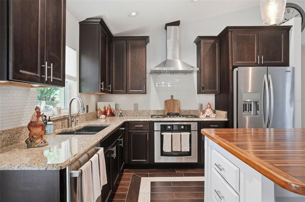 7037 County Road 625 Bushnell, FL 33513 - Photo 6 of 99 a kitchen with stainless steel appliances granite countertop a sink stove and refrigerator