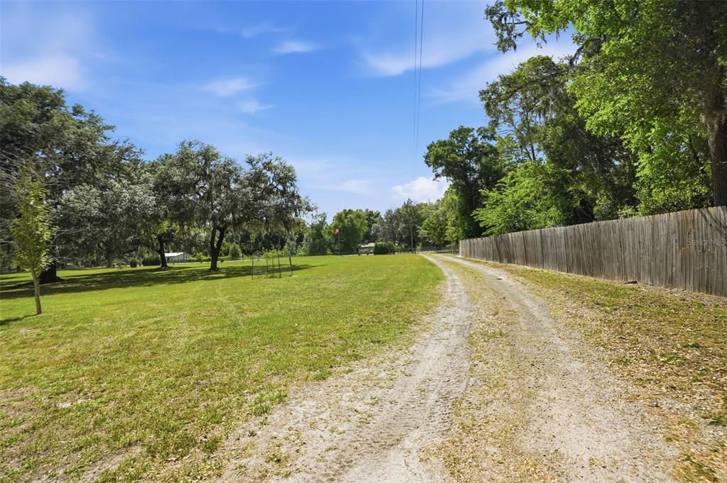 7037 County Road 625 Bushnell, FL 33513 - Photo 63 of 99 a view of yard with swimming pool and wooden fence