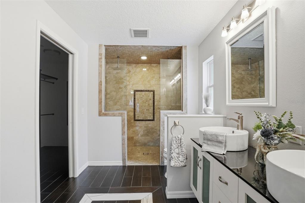 7037 County Road 625 Bushnell, FL 33513 - Photo 9 of 99 a bathroom with a sink a mirror and a shower
