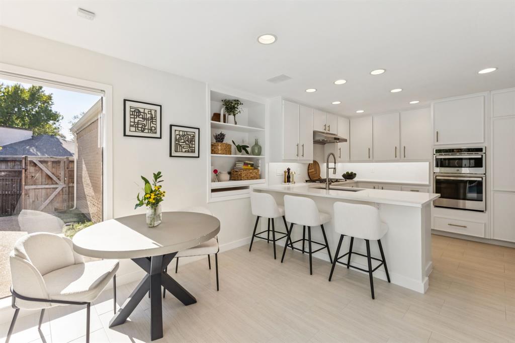 9616 Viewside Drive Dallas, TX 75231 - Photo 13 of 38 Kitchen with white cabinetry, recessed lighting, a kitchen bar, stainless steel double oven, and a peninsula
