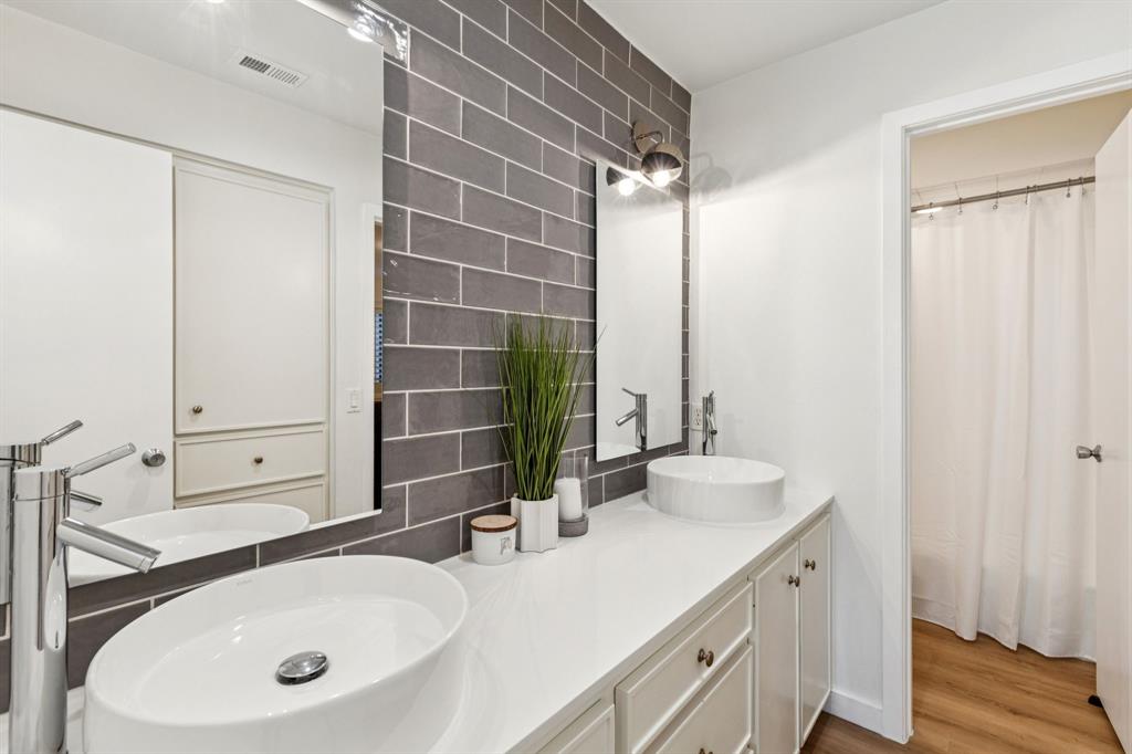 9616 Viewside Drive Dallas, TX 75231 - Photo 23 of 38 Full bath with double vanity, tile walls, a shower with shower curtain, and light wood-style floors
