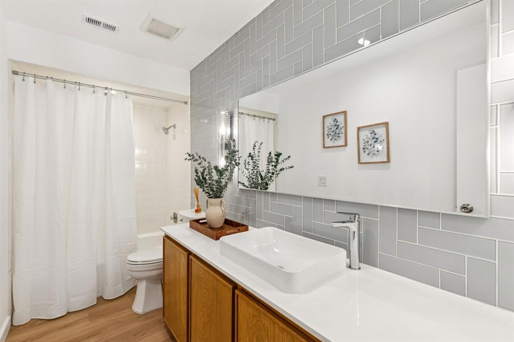 9616 Viewside Drive Dallas, TX 75231 - Photo 25 of 38 Full bathroom featuring tasteful backsplash, shower / tub combo, vanity, and light wood-type flooring