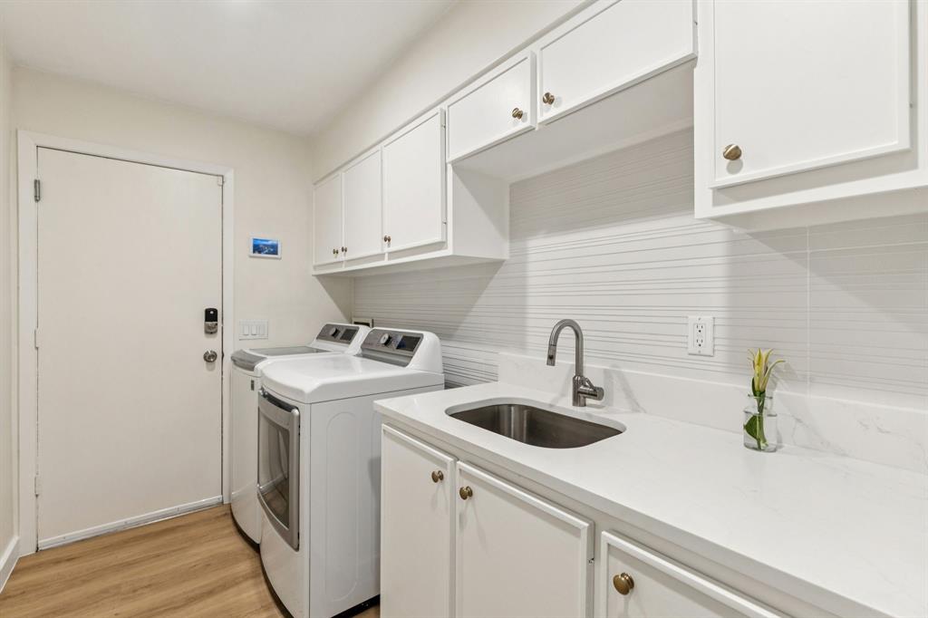 9616 Viewside Drive Dallas, TX 75231 - Photo 30 of 38 Laundry room with washing machine and dryer, light wood-type flooring, and cabinet space