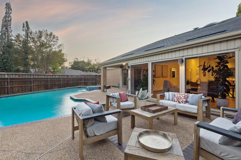 9616 Viewside Drive Dallas, TX 75231 - Photo 35 of 38 Pool at dusk featuring a fenced backyard, outdoor lounge area, a patio area, and a pool with connected hot tub