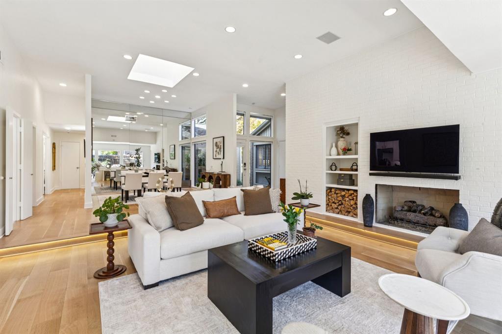 9616 Viewside Drive Dallas, TX 75231 - Photo 8 of 38 Living area featuring built in features, a brick fireplace, wood-type flooring, recessed lighting, and a skylight