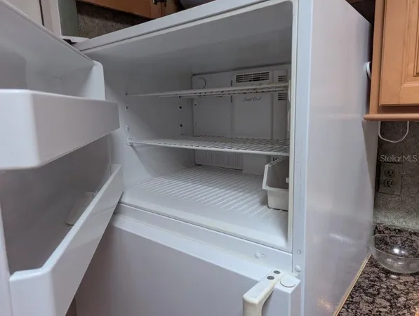 a kitchen with granite countertop a sink a stove and cabinets