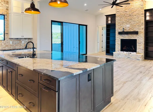 a kitchen with granite countertop a sink and a wooden cabinets