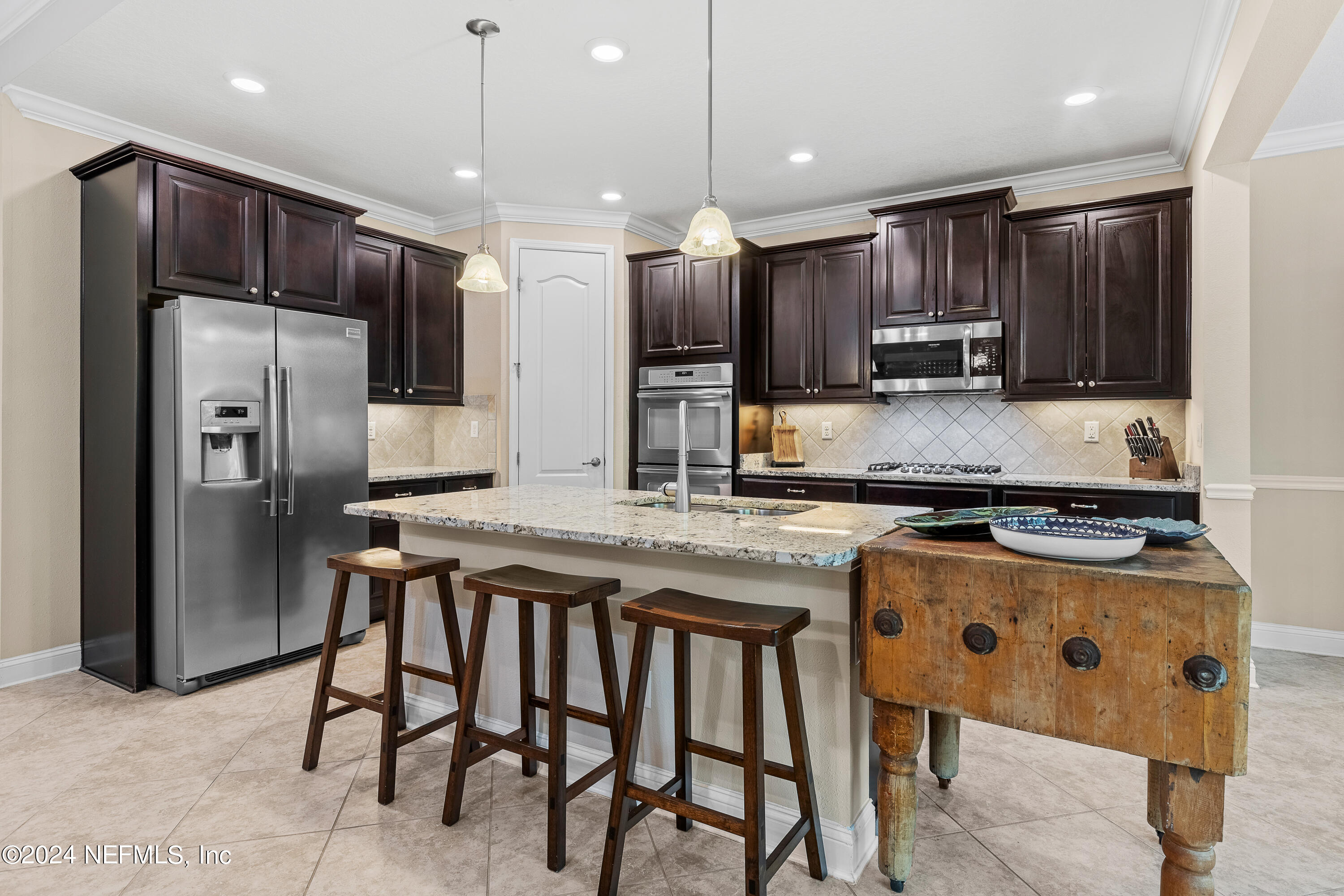 405 St Kitts Loop St. Augustine, FL 32092 - Photo 18 of 65 a kitchen with stainless steel appliances granite countertop a stove refrigerator sink and microwave