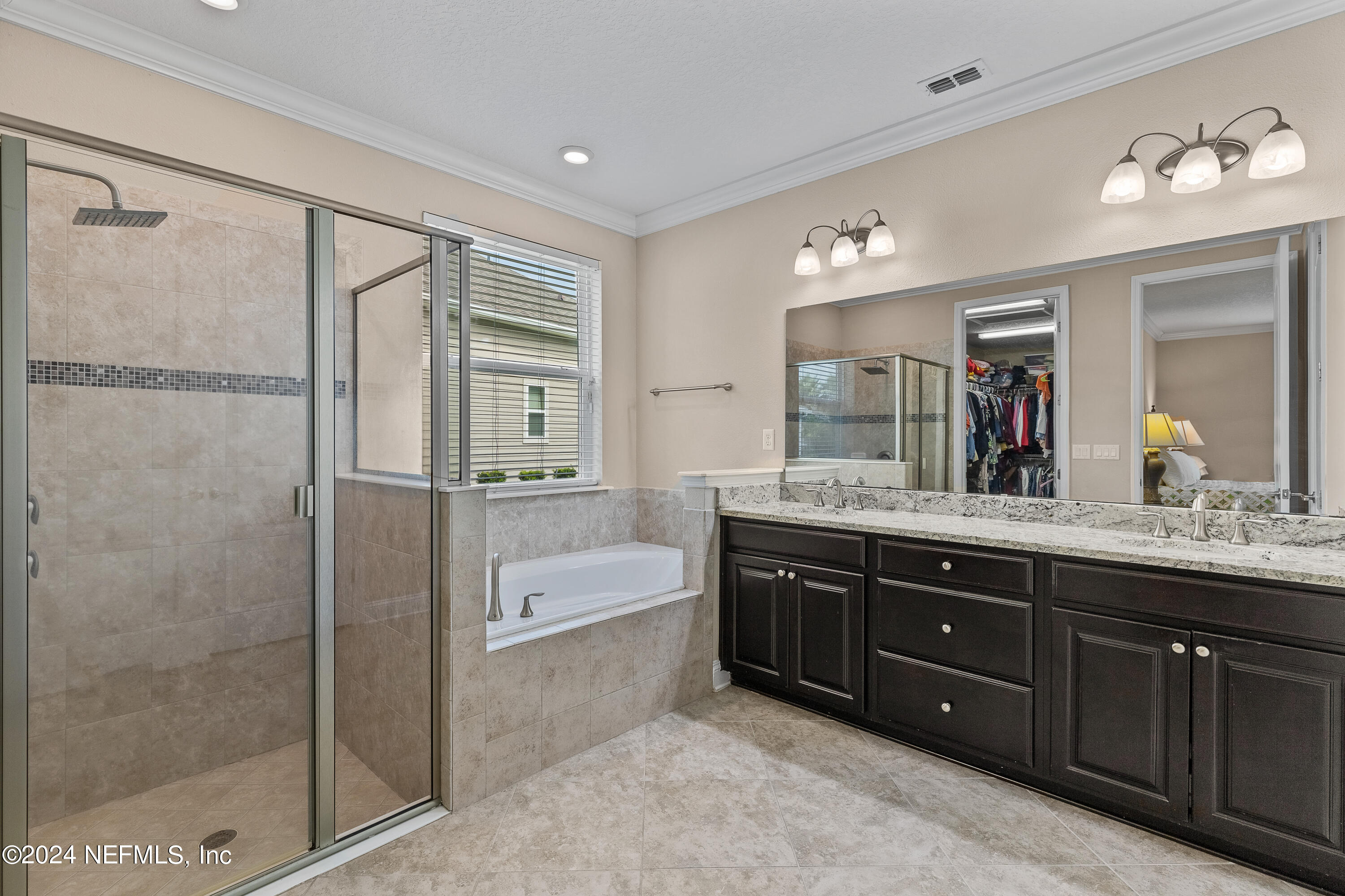 405 St Kitts Loop St. Augustine, FL 32092 - Photo 28 of 65 a bathroom with a tub a sink double vanity and a mirror