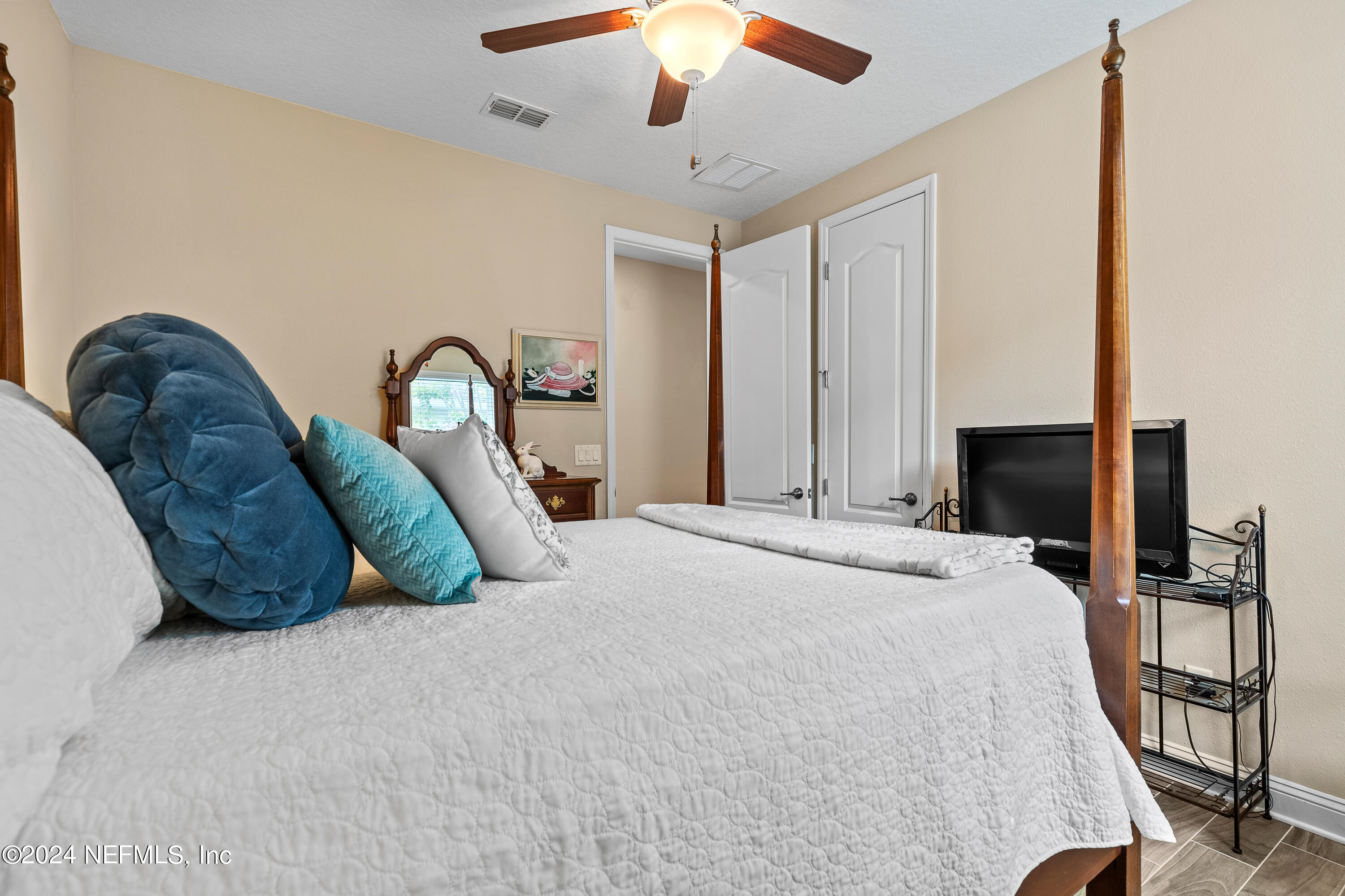 405 St Kitts Loop St. Augustine, FL 32092 - Photo 30 of 65 a spacious bedroom with a bed and a chandelier