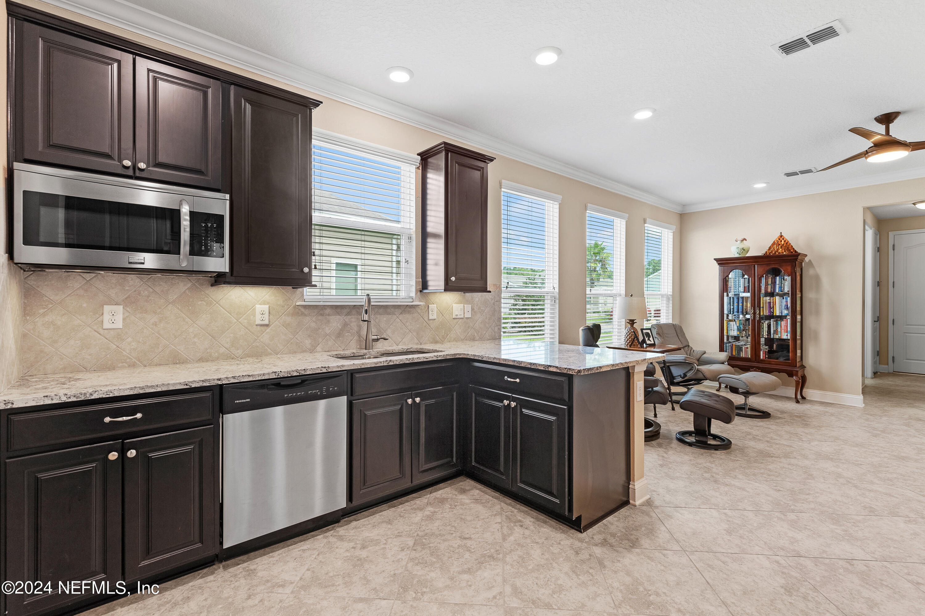 405 St Kitts Loop St. Augustine, FL 32092 - Photo 39 of 65 a large kitchen with stainless steel appliances granite countertop a sink and dishwasher a stove top oven with wooden floor