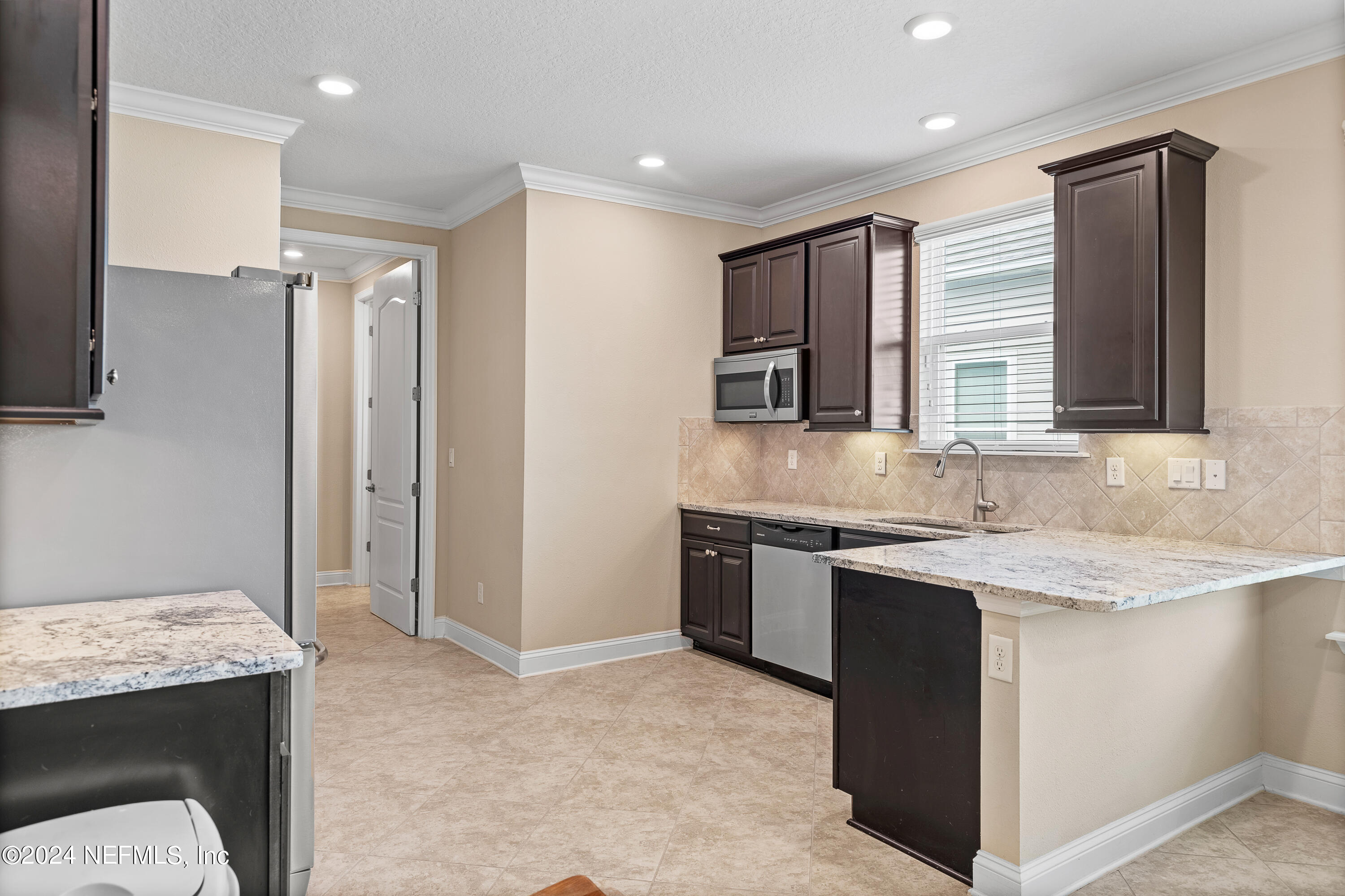 405 St Kitts Loop St. Augustine, FL 32092 - Photo 42 of 65 a kitchen with stainless steel appliances granite countertop a sink stove and refrigerator