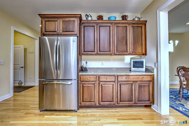 a kitchen with granite countertop a refrigerator and a stove top oven
