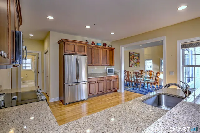 a kitchen with stainless steel appliances granite countertop a refrigerator and a sink