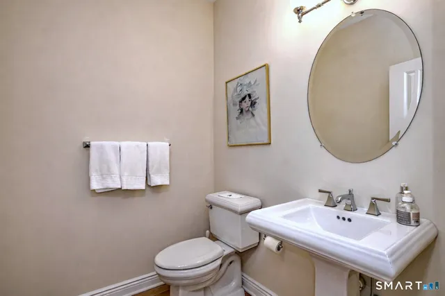 a bathroom with a toilet a sink and mirror