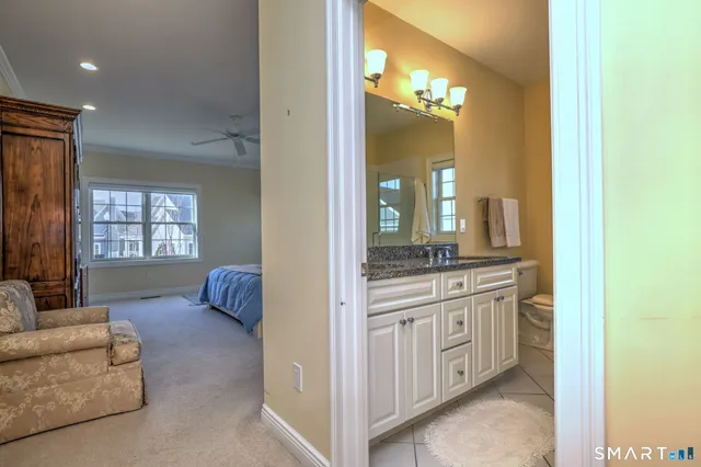 a spacious bathroom with a granite countertop sink a mirror and a bathtub