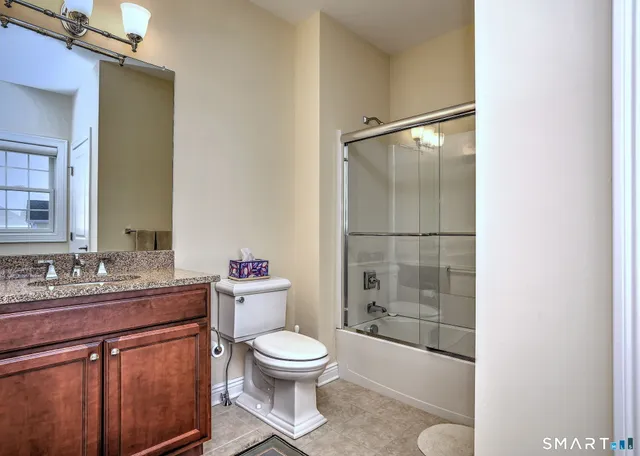 a bathroom with a sink toilet vanity and shower