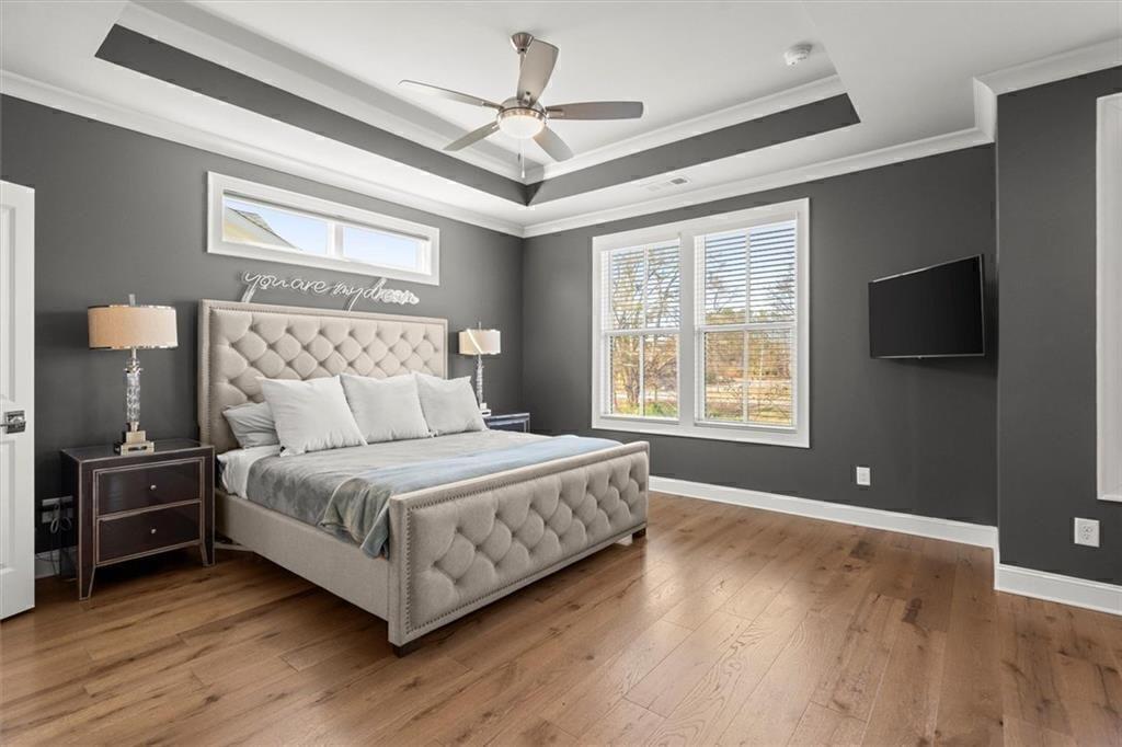 209 Phillips Lane Alpharetta, GA 30009 - Photo 18 of 48 a spacious bedroom with a bed and a flat tv screen on dresser
