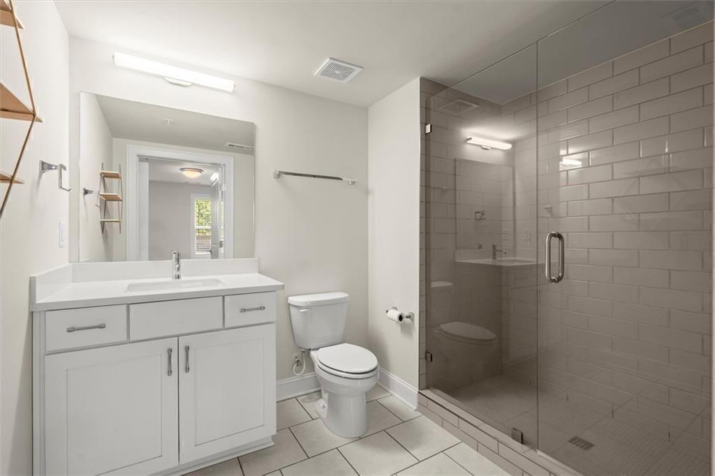 209 Phillips Lane Alpharetta, GA 30009 - Photo 32 of 48 a bathroom with a toilet a sink a shower and mirror