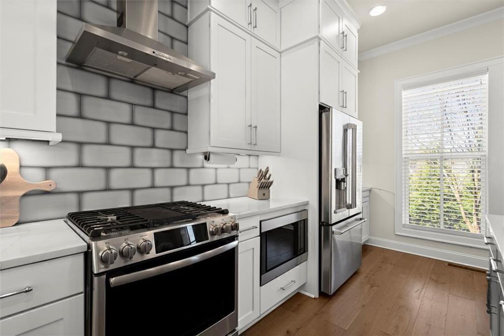 209 Phillips Lane Alpharetta, GA 30009 - Photo 7 of 48 a kitchen with stainless steel appliances a stove a refrigerator and a window