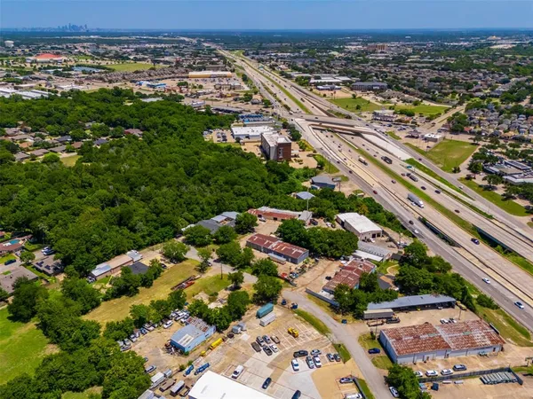 an aerial view of residential houses with outdoor space and trees