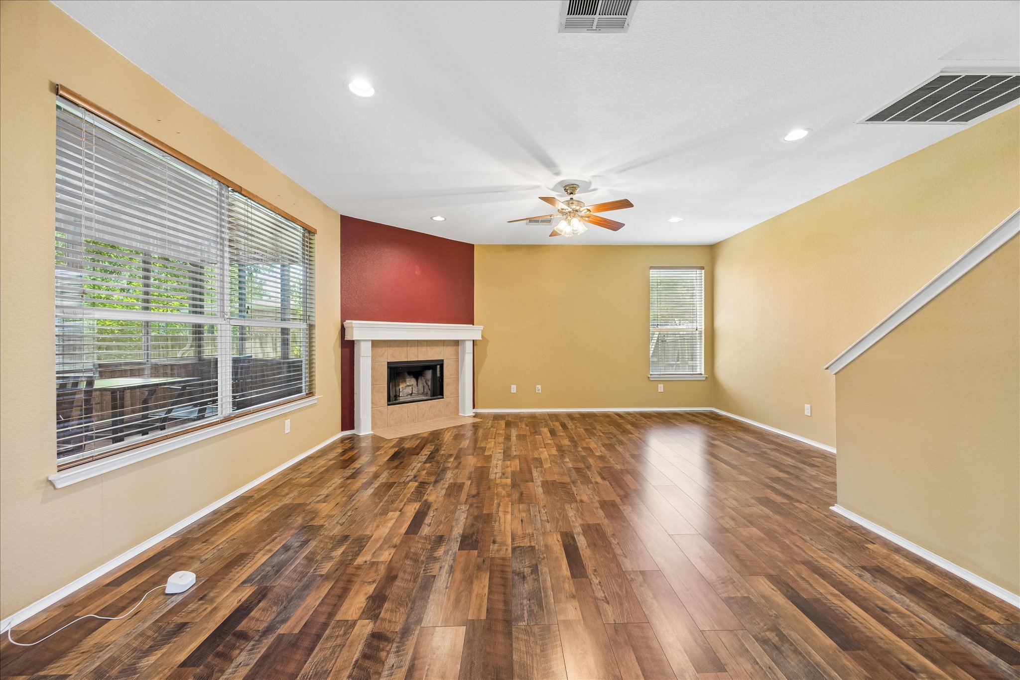 338 Spring Branch Loop Kyle, TX 78640 - Photo 11 of 36 A well-lit gathering space showcases rich hardwood flooring and a classic fireplace.