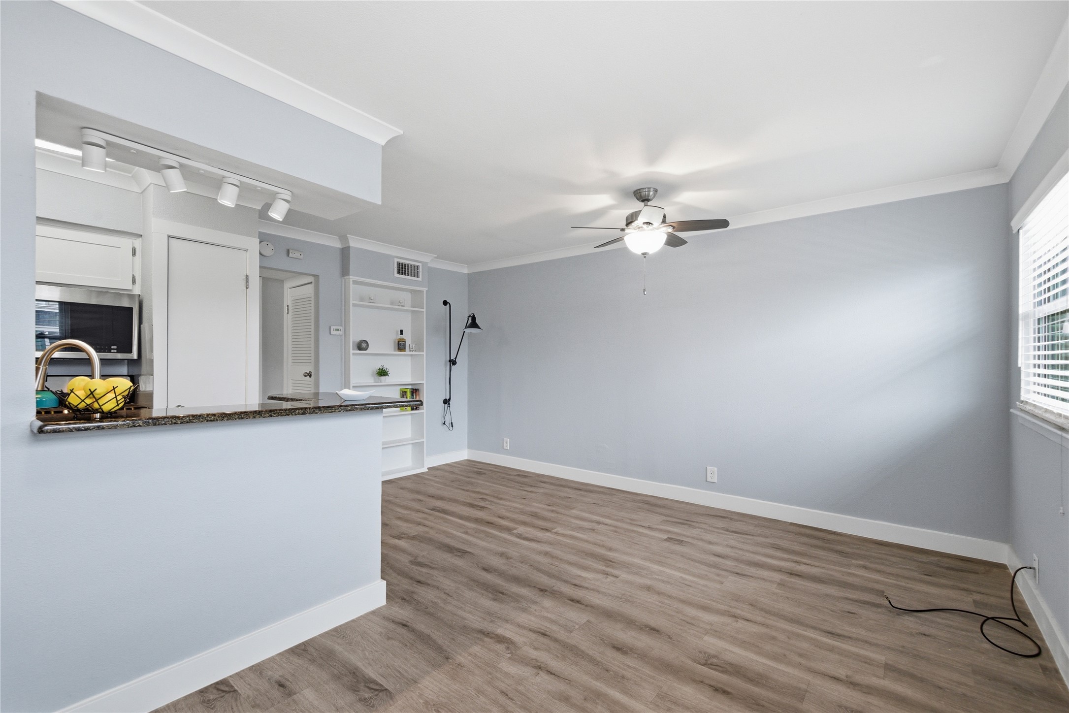 2401 Manor Road, Unit 232 Austin, TX 78722 - Photo 4 of 32 a view of a livingroom with a furniture ceiling fan and wooden floor