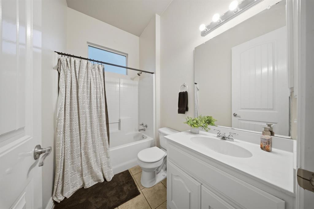 603 Cedar Drive Pilot Point, TX 76258 - Photo 28 of 39 Full bathroom featuring a white vanity with integrated sink, chrome faucet, and expansive mirror