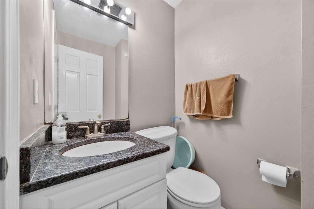 68 Jericho Road, Unit 68 Weston, MA 02493 - Photo 5 of 25 a bathroom with a granite countertop sink mirror vanity and toilet