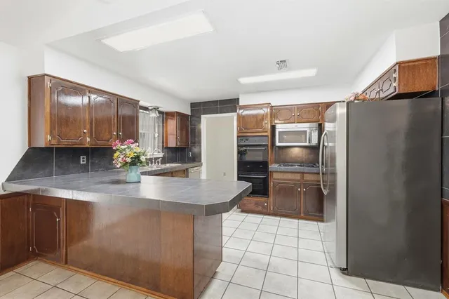 a kitchen with kitchen island a counter top space cabinets and stainless steel appliances