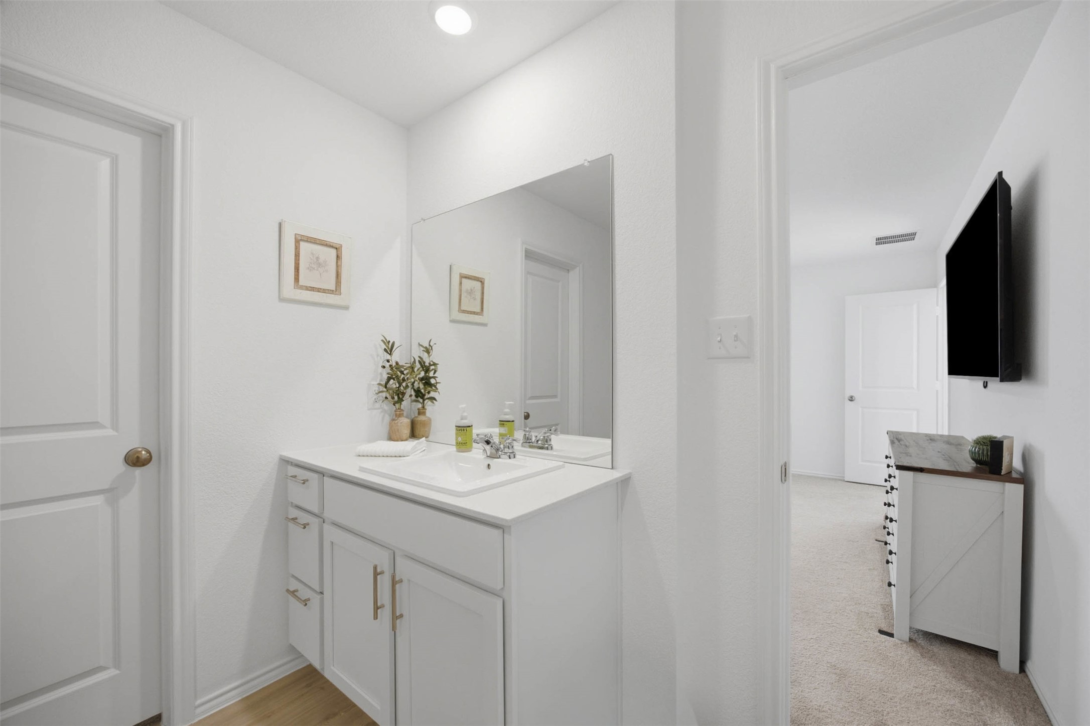 171 Cattle Queen Road Jarrell, TX 76537 - Photo 23 of 38 Recessed lighting illuminates a modern vanity with clean lines and adjacent bedroom views.