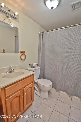 a bathroom with a granite countertop sink a toilet and a mirror