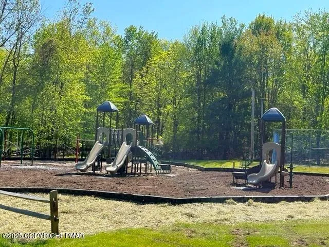 a view of a house with a yard and a park