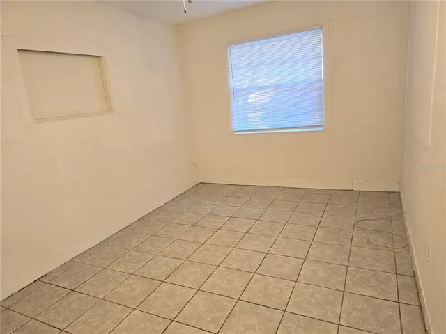 an empty room with a white cabinet and door