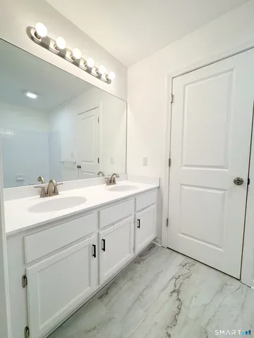a bathroom with a double vanity sink and a mirror