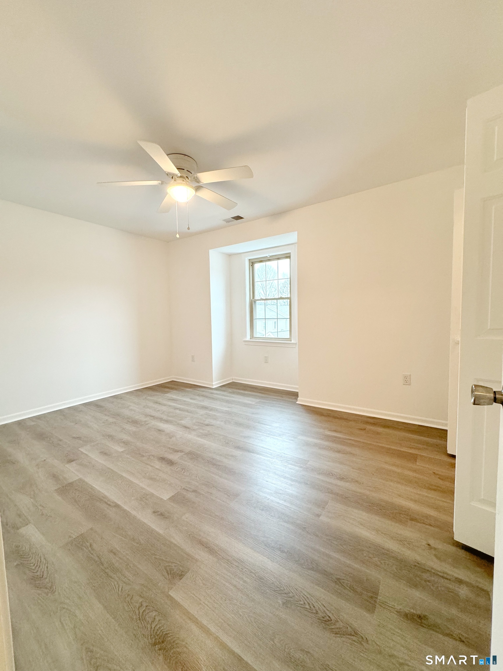 1229 Winsted Road, Unit 116 Torrington, CT 06790 - Photo 19 of 20 an empty room with wooden floor and windows