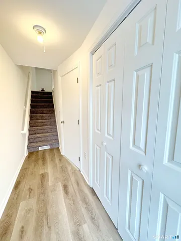 a view of a hallway with wooden floor and staircase