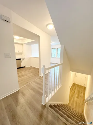 a view of a bedroom with wooden floor and windows