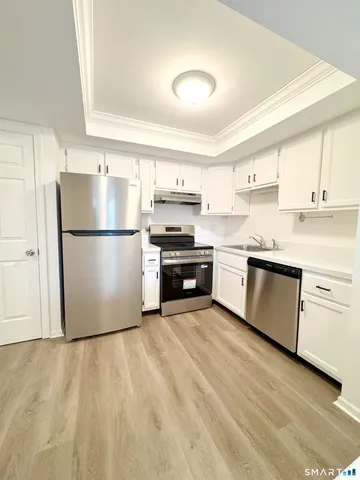 a kitchen with a refrigerator and a stove top oven