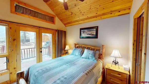 a bedroom with a bed and a lamp on dresser