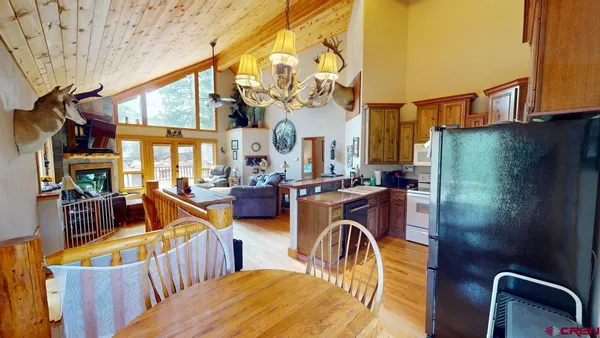 a view of a dining room with furniture a chandelier and wooden floor