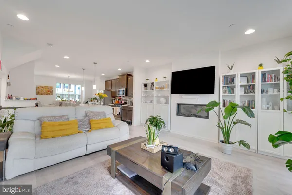 a living room with furniture a flat screen tv and a potted plant