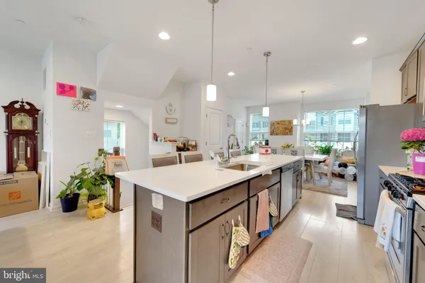 a kitchen with kitchen island a sink appliances and a counter top space