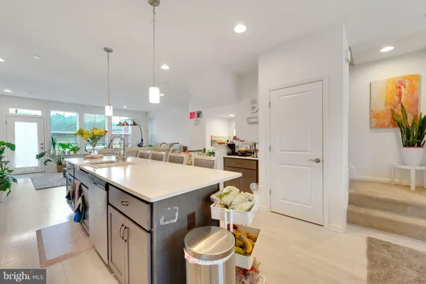 a kitchen with a sink and a stove top oven with wooden floor