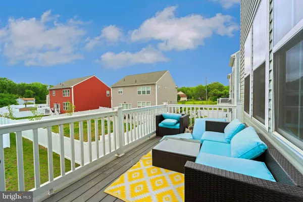 a view of a balcony with two couches and a potted plant on a table and chairs