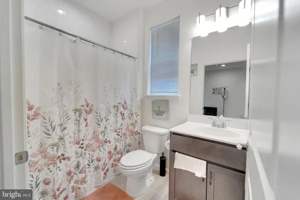 a bathroom with a sink a toilet and shower curtain