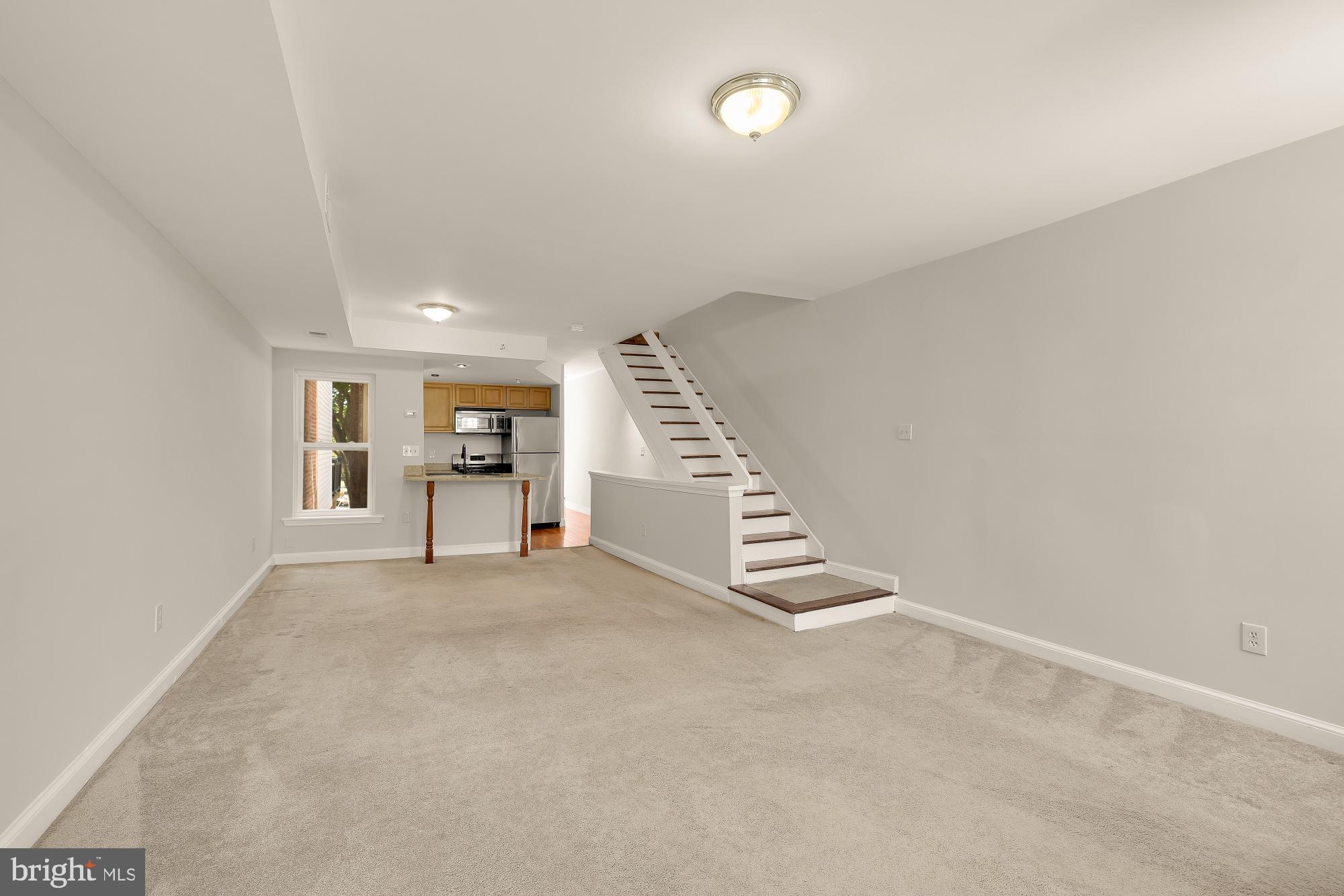 601 L Street Northeast Washington, DC 20002 - Photo 30 of 47 an empty room with staircase and kitchen view