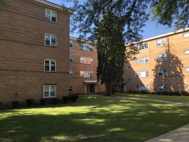 a view of a large brick building next to a yard