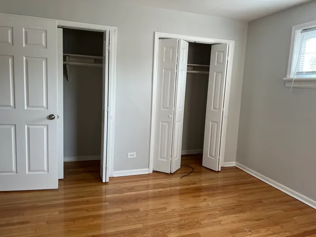 an empty room with wooden floor and closet